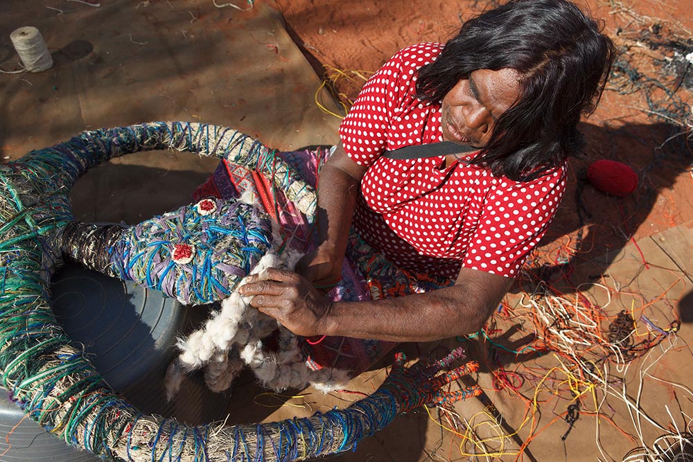 'Jennifer adds <em>mangka</em> (hair) to the sculpture. The hair is made of twined sheep’s wool secured with raffia.'